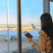 vrouw met paspoort kijkend naar vliegtuig